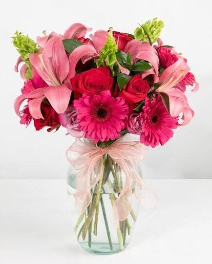 Florero con 4 gerberas, 3 lilis, 24 rosas y follaje mixto