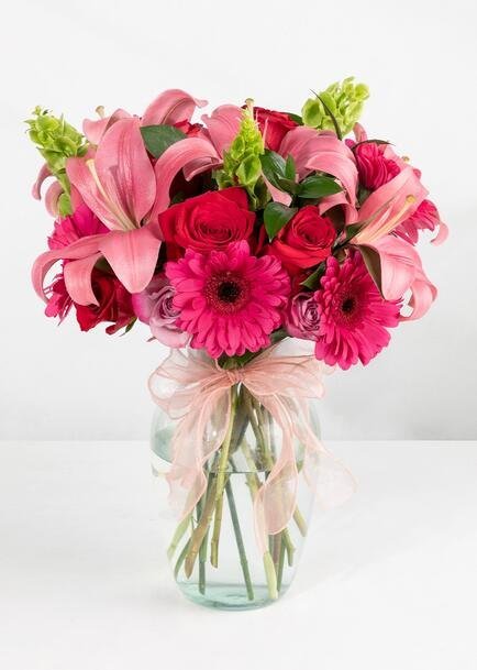 Florero con 4 gerberas, 3 lilis, 24 rosas y follaje mixto