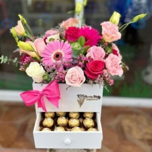 Arreglo floral con 3 gerberas, 8 rosas en tonos pastel y follaje mixto, 15 chocolates Ferrero Rocher en cajonera
