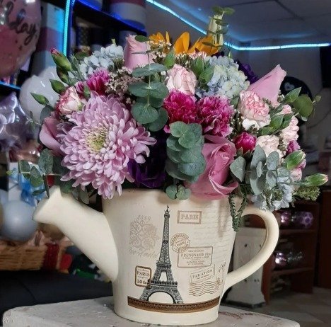 Jarrón con rosas en tonos lilas y follaje mixto