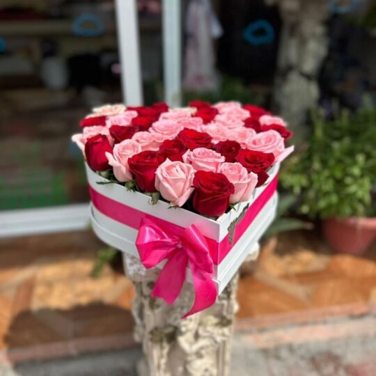 Caja con rosas rojas y rosas en forma de corazón